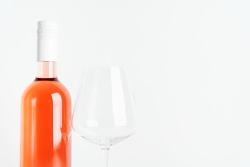 Bottle of rose wine for label layout with glass of wine on white background.