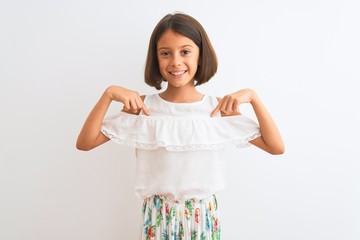 Young beautiful child girl wearing casual dress standing over isolated white background looking...