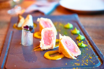 Sliced tuna tempura are on the plate with sauce