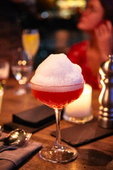 Pink cocktail with a big foam cap.