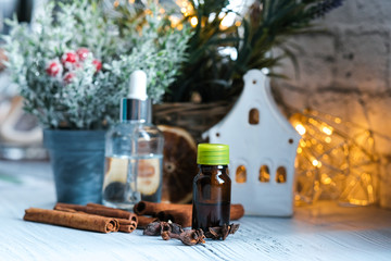 Relaxing winter season Essential oils blend. Dark glass bottles, cinnamon, orange, pine twigs, anise.