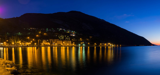 Fototapeta na wymiar Anochecer en Tórbole sobre el Lago de Garda en Italia, invierno Navidad de 2018