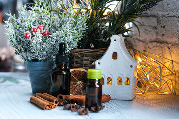 Relaxing winter season Essential oils blend. Dark glass bottles, cinnamon, orange, pine twigs, anise.