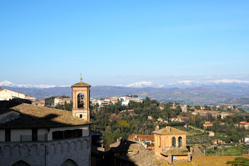 Fototapeta na wymiar Skyline of Assisi in Umbria with snow covered mountains in the background 