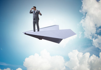 Businessman flying on paper plane in business concept