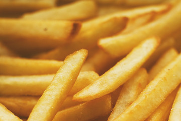 French fries close up. Saturated golden-yellow color. It can be used as background. The concept of fast food, delicious food, restaurants, cafes, etc.