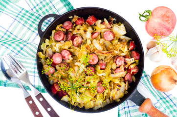 Fried cabbage with smoked sausages in pan