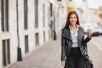 Asian woman beauty model walking in Europe city street urban lifestyle .Young elegant people travel fashion multiracial girl walking in leather jacket in autumn fall. Multiracial Caucasian model.