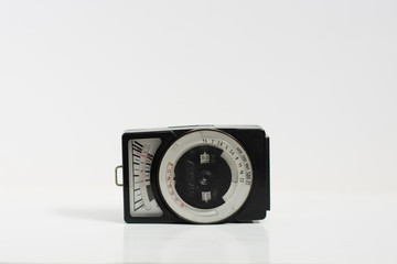 old selenium light meter for analog cameras on isolated white background. This device measures the intensity of the light for photography. horizontal view