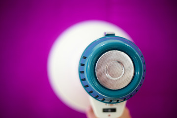 Woman holding megaphone on color background