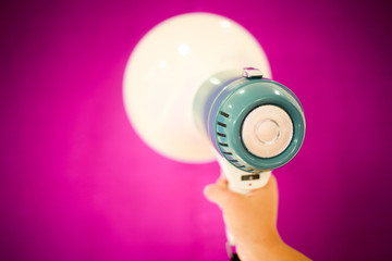 Woman holding megaphone on color background