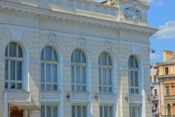 a row of old windows on the white wall of a large building