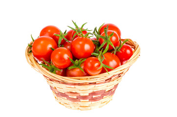 Wicker bowl with red tomatoes. Studio Photo
