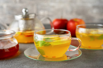 A glass cup of fruit tea on grey background