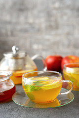 A glass cup of fruit tea on grey background