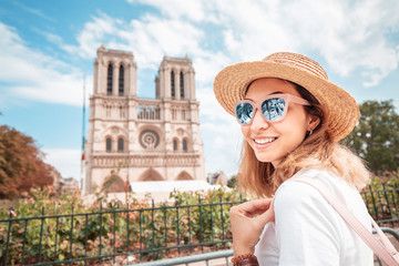 Happy asian woman visiting famous Notre Dame Cathedral after the Fire. Europe travel and...