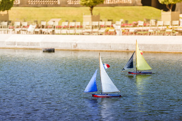 sailing regatta with small toy boats and sailboats in a pond