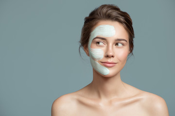 Portrait of beautiful woman with bluel cream mask on her face.