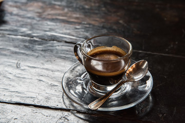 Glass cup with coffee on a wooden table