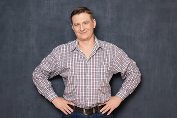 Obraz premium Portrait of confident man holding hands on waist