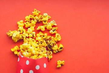 Popcorn in a paper bag on a red background.