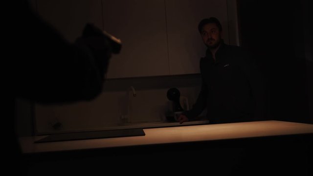 Two dangerous hooligans surprise scared young man owner threaten with handgun at night. Night robbery in the city.