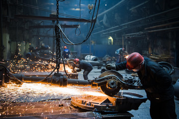 Welder used grinding stone on steel in factory with sparks - obrazy, fototapety, plakaty