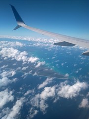 wing of an airplane flying above the clouds cancun