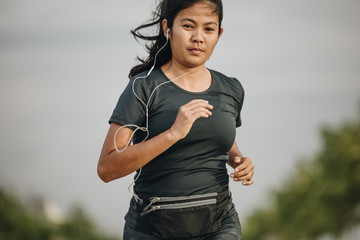 Young Asian woman running on the road , Concept fitness ,health care concept