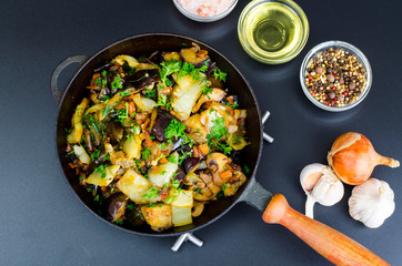 Fried eggplant, paprika and different vegetables in pan on black background