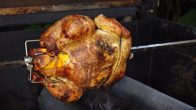 Side angle of rotisserie chicken in BBQ