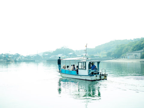Small ferry approaching to Asian town