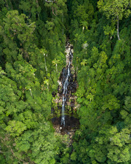Fototapeta premium Beautiful aerial view of a waterfall at sunrise in the middle of a rainforest. Beautiful hike, walk, adventure location in Australia, Queensland, Twin Falls circuit