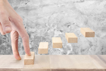 Hand liken person stepping up  toy staircase wood