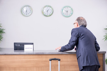 Old businessman at the hotel reception