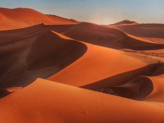Sun rising over the red sand dunes of the Namib Desert, Namibia.