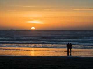 A Couple in Silhouette Watching Sunset over Pacific Ocean