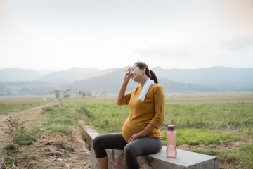 Fototapeta premium pregnant woman sit while jogging outdoor take a break