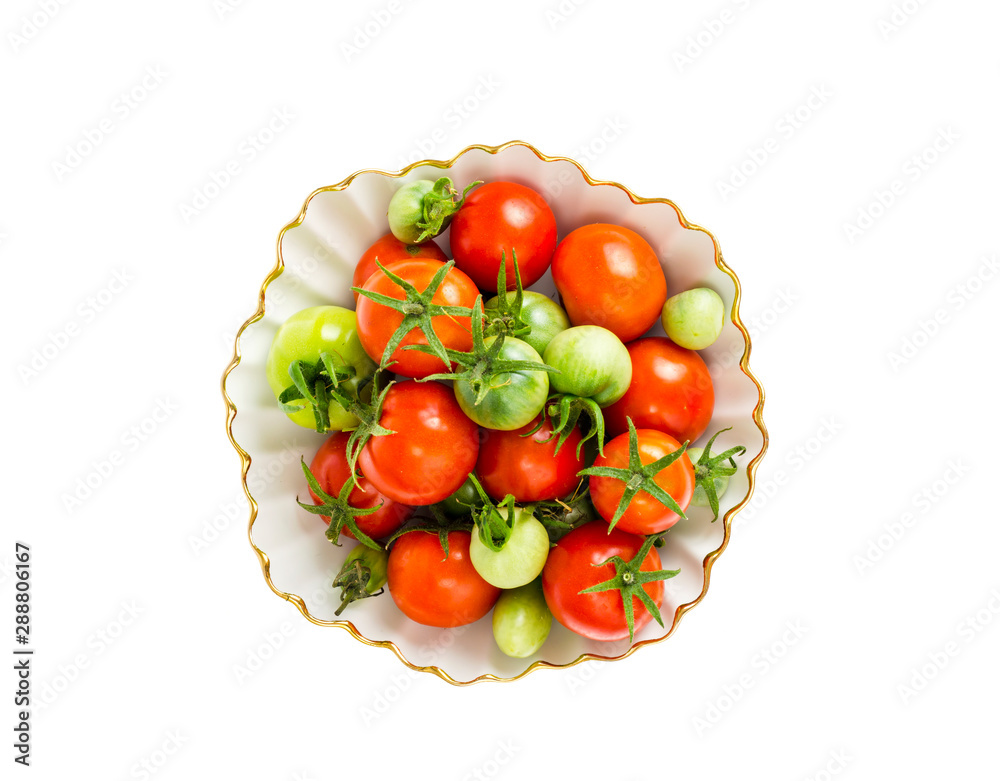 Poster small red and green tomatoes in white bowl.