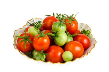Small red and green tomatoes in white bowl.