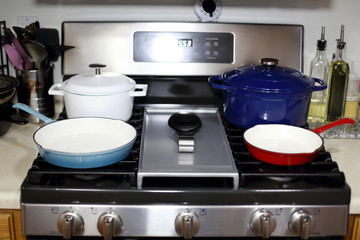 Cast iron porcelain enameled cookware on the stove top in a home kitchen.