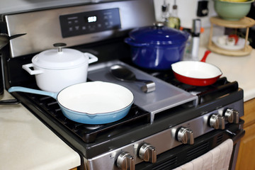 Cast iron porcelain enameled cookware on the stove top in a home kitchen.