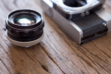 Selective focus of Old film camera and lens on  wooden background