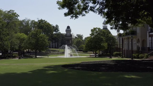 A child running to play in a water fountain on the town square.
