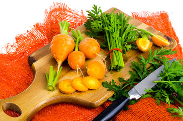 Bunch of small, round carrots (Parisian Heirloom Carrots) on wooden background.