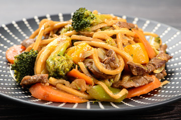 yakisoba on a black plate on a table
