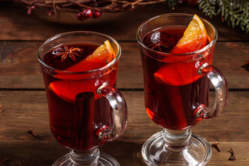 Christmas hot mulled wine with cinnamon cardamom and anise on wooden background