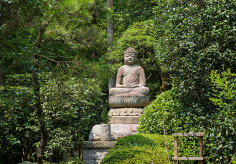 Statue of Buddha in the woods in Kyoto, Japan.