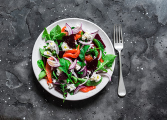 Beetroot, smoked salmon, arugula, soft cheese salad on dark background, top view