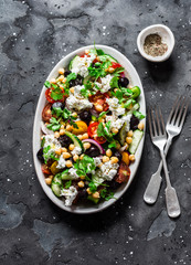 Greek chickpeas salad on dark background, top view. Vegetarian healthy diet food
